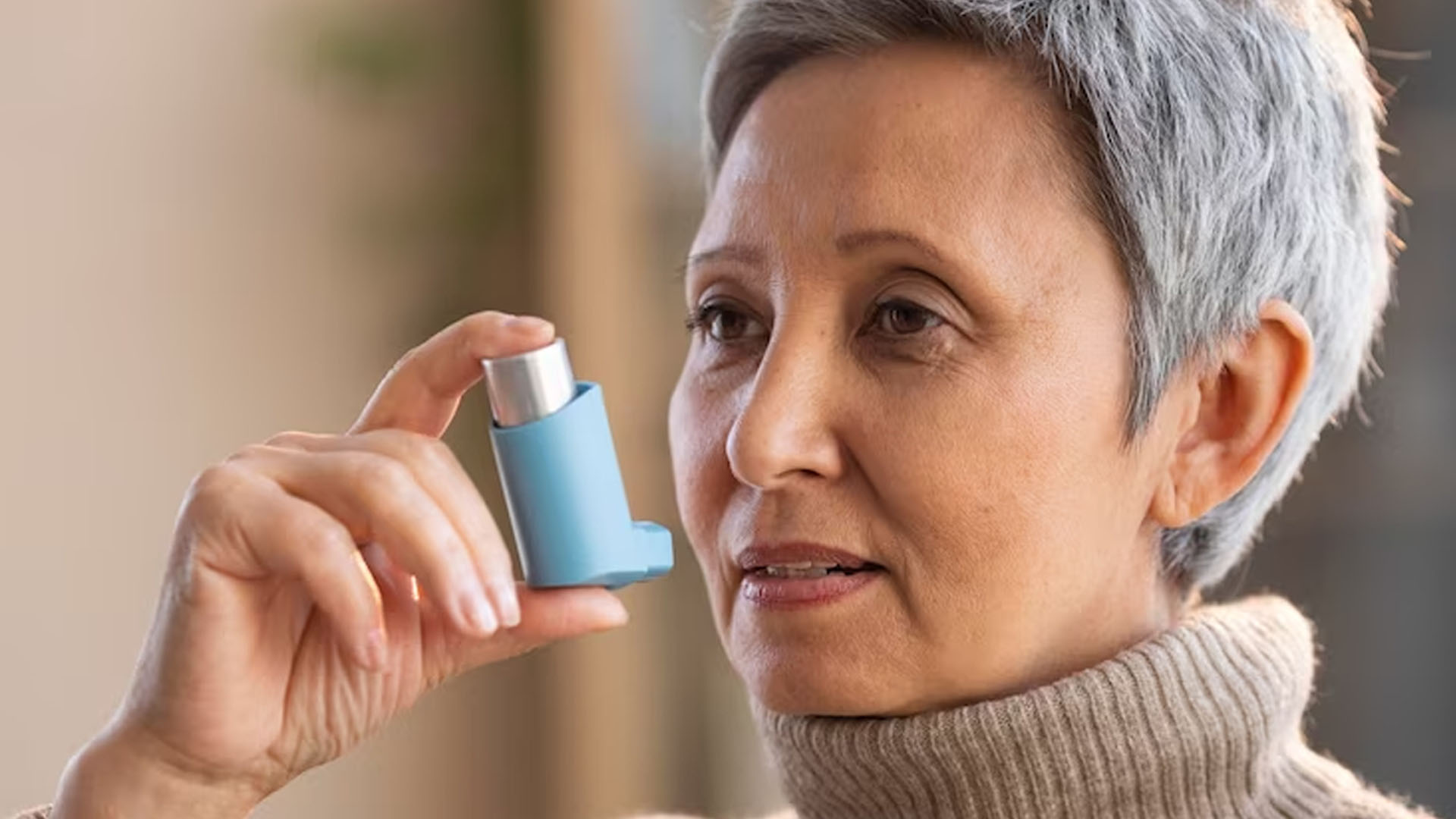 woman holding asthma inhaler