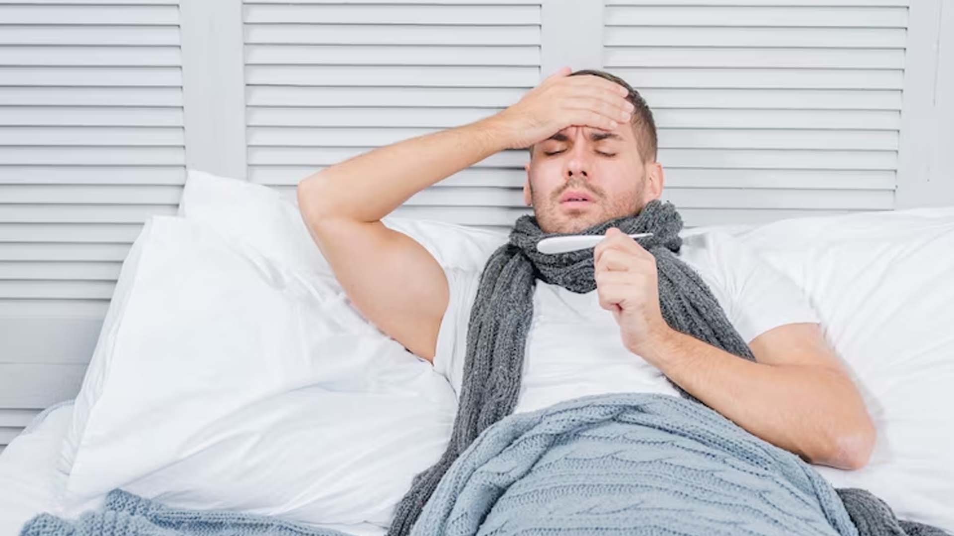 Strong man checking fever with thermometer