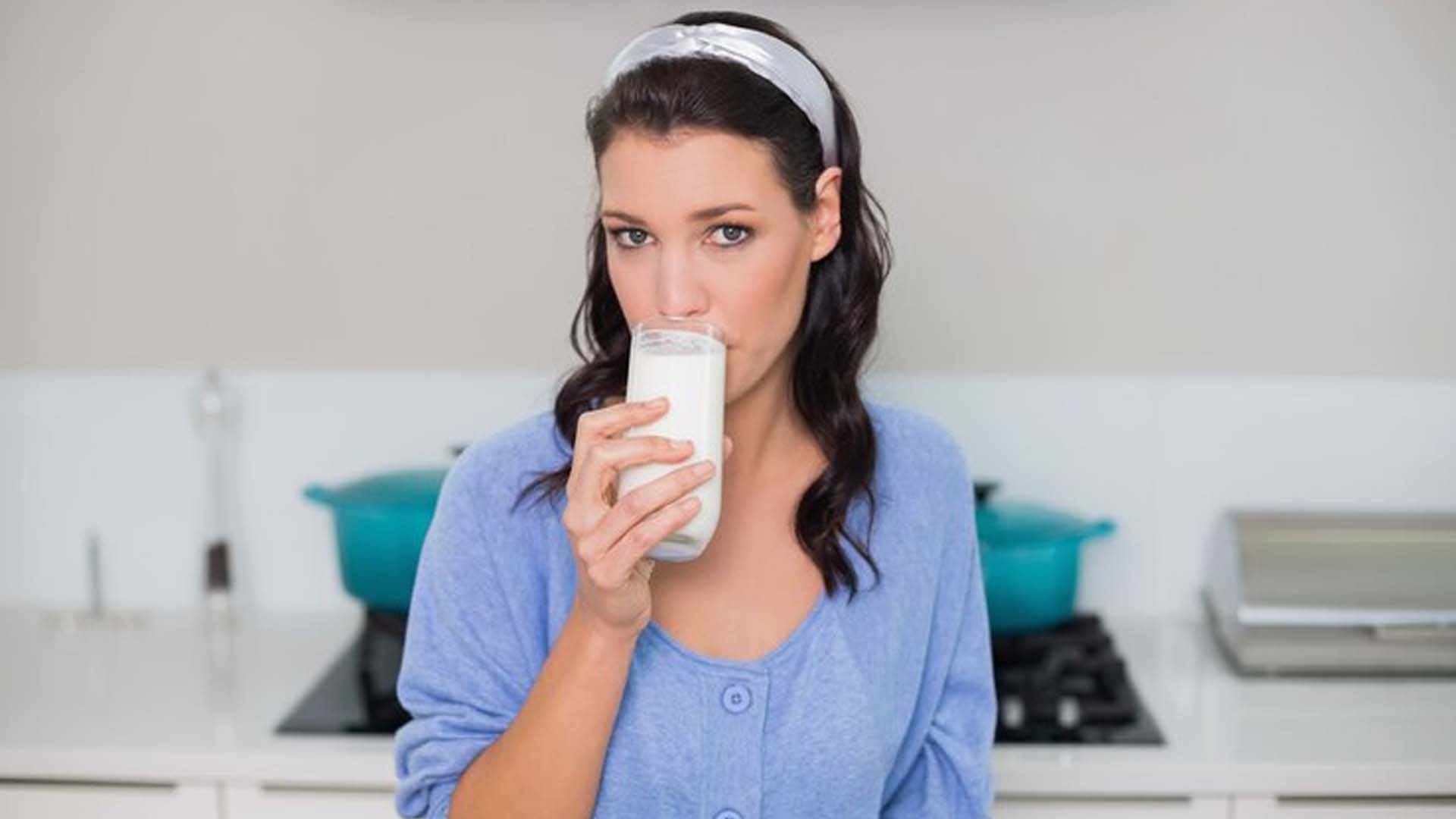Women Drinking Milk in Kitchen