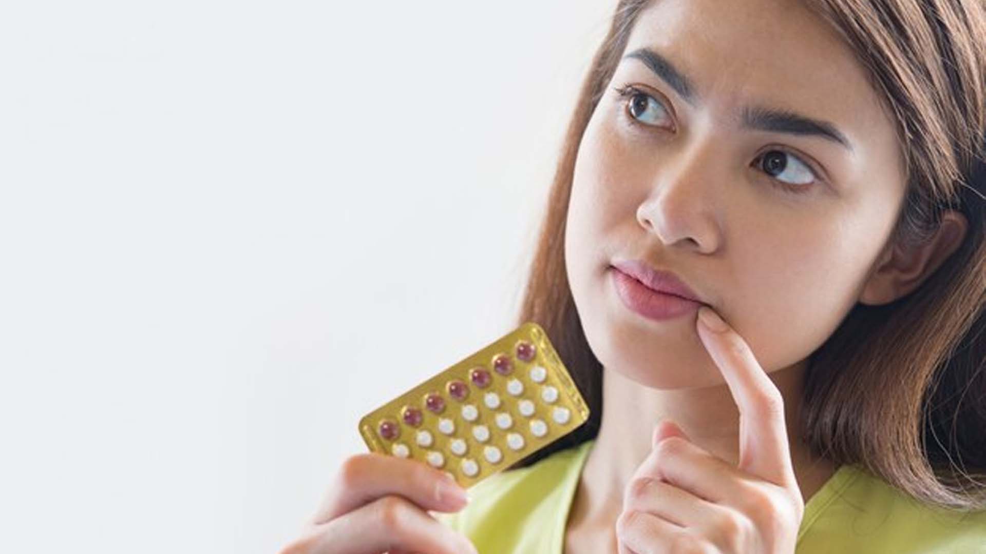 Women Holding contraceptive Pills and Thinking