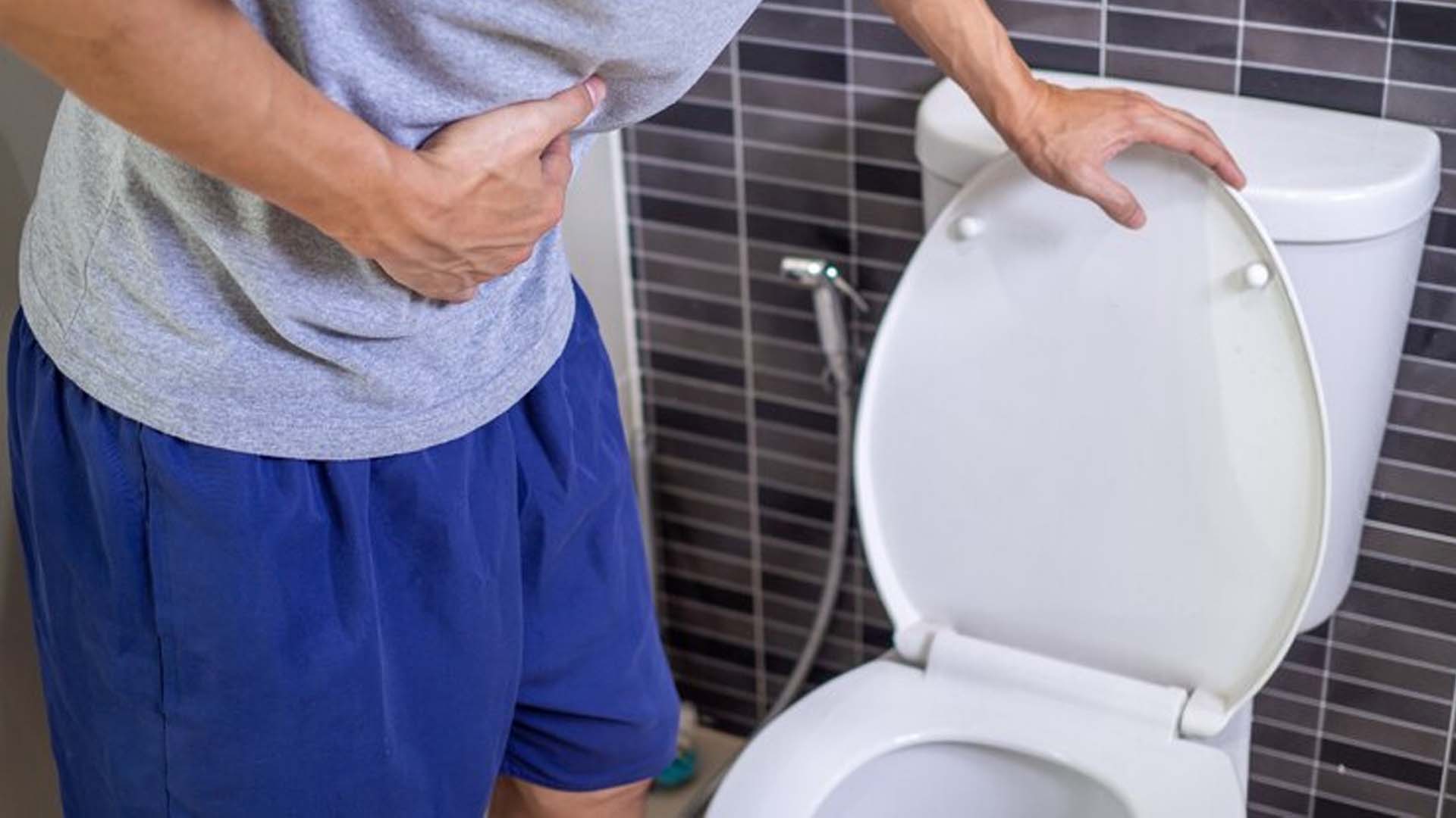 Man holding Stomach in washroom