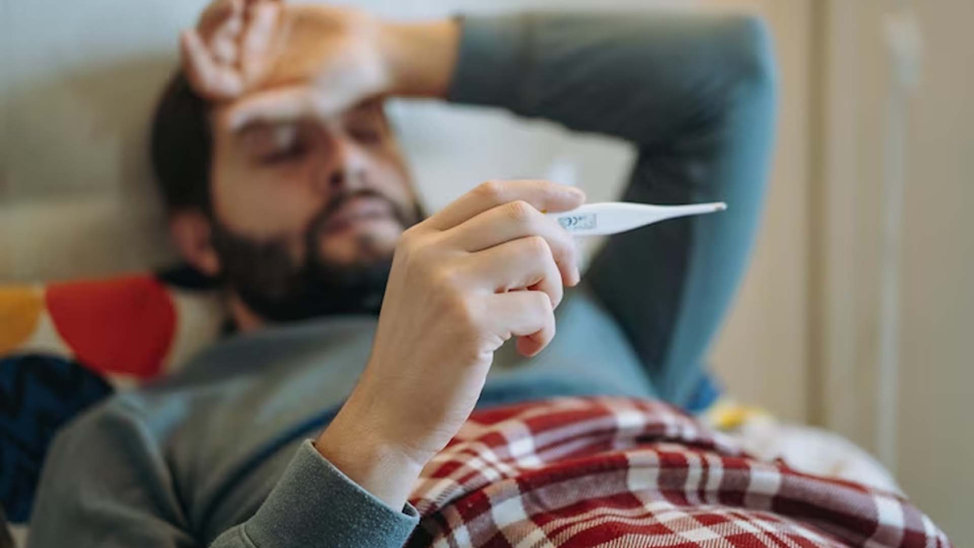 Man in bed Checking Fever