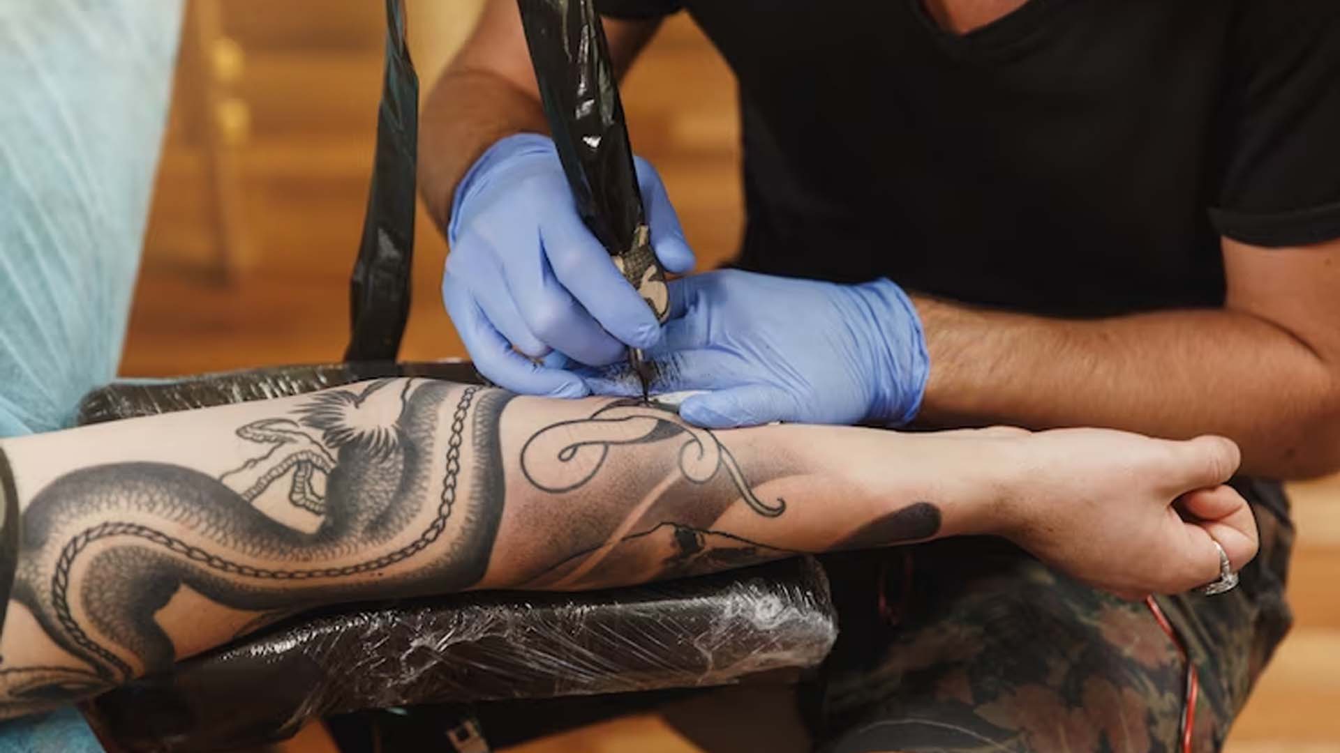 Tattoo artist doing Tattoo on hand