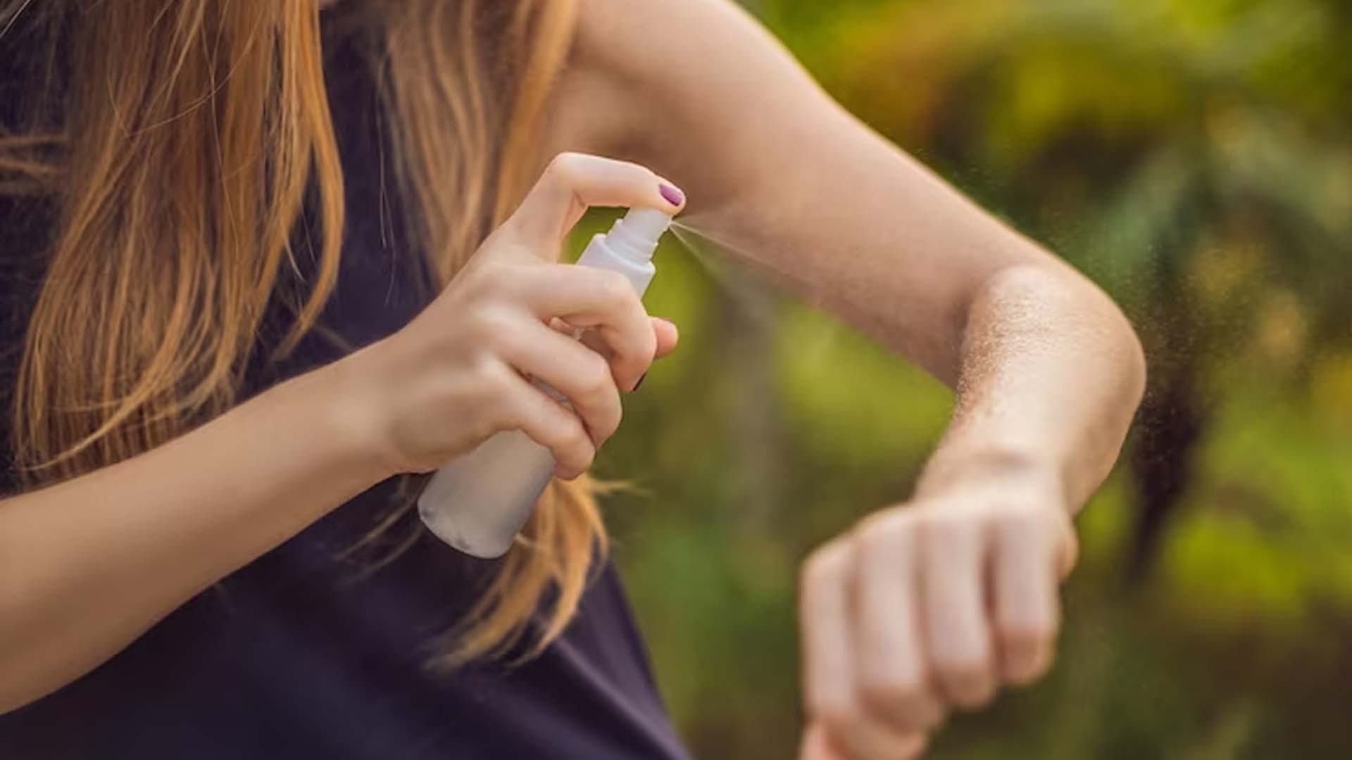Women spraying Mosquito repellent